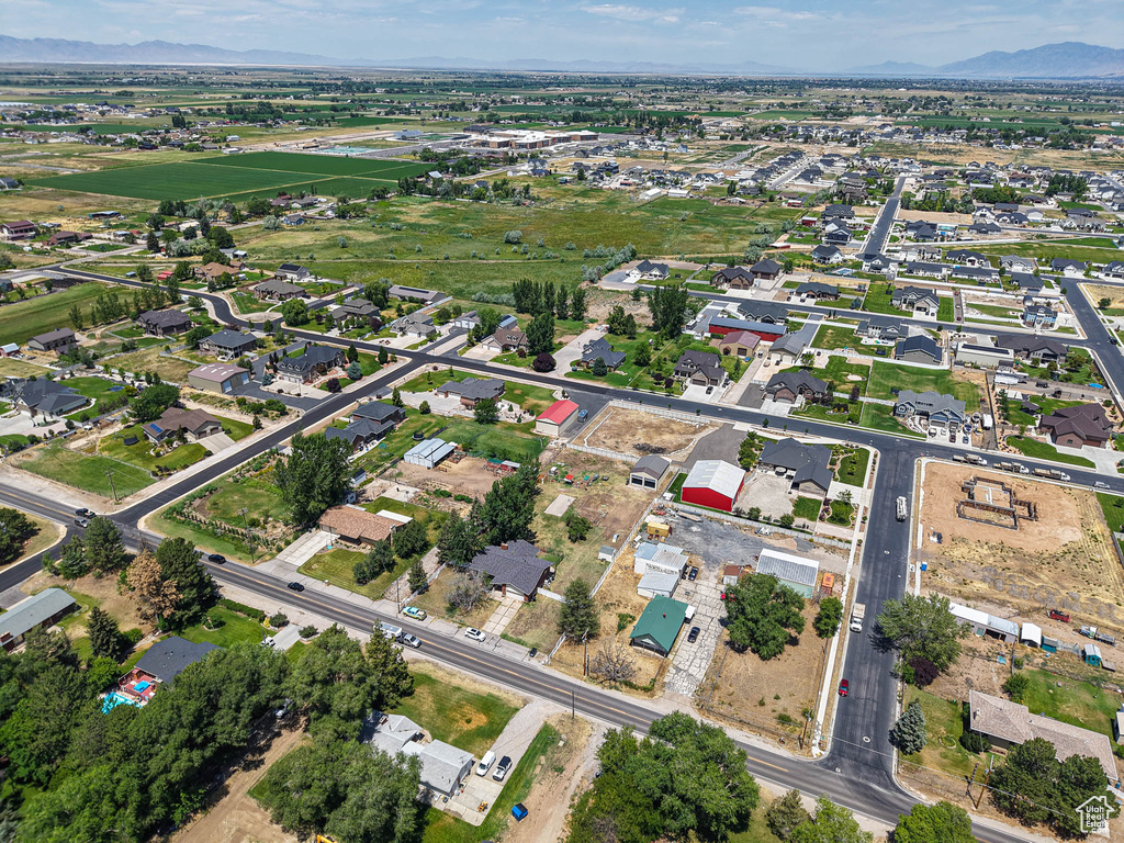 Aerial view of property and surrounding area featuring a mountainous background and nearby suburban area