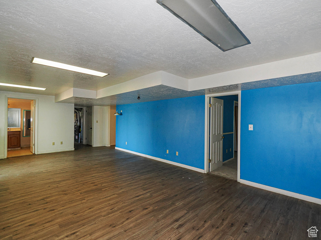 Empty room with a textured ceiling and wood finished floors