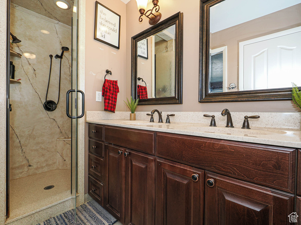 Bathroom featuring double vanity and a marble finish shower