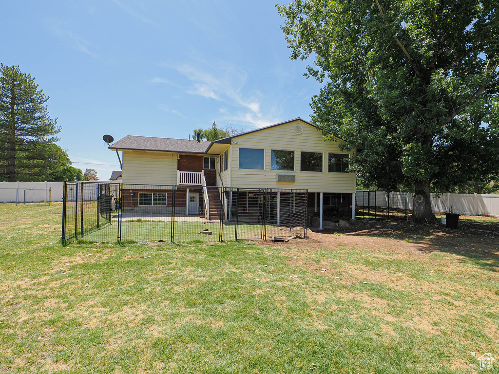 Back of property featuring a fenced backyard and a gate