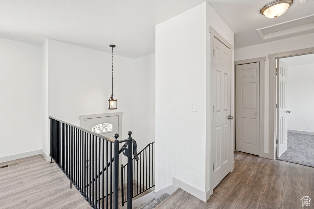 Hallway featuring an upstairs landing and wood finished floors