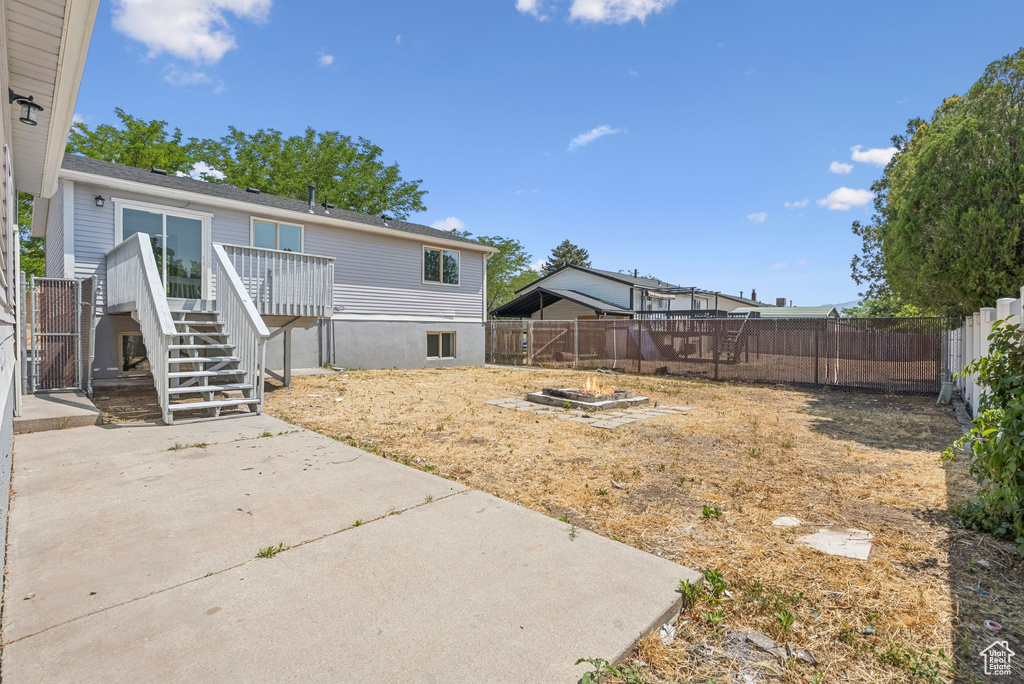 Fenced backyard featuring a patio, stairway, a deck, and an outdoor fire pit