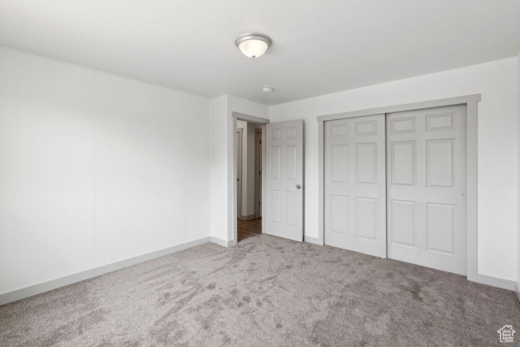 Unfurnished bedroom with carpet flooring and a closet