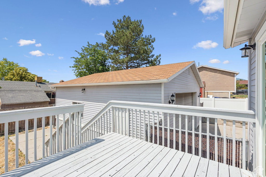 Wooden deck featuring a garage and an outdoor structure