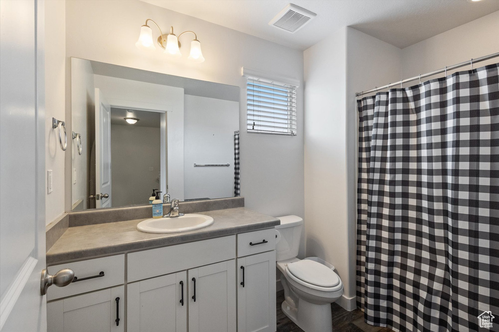 Bathroom with vanity, curtained shower, and wood finished floors