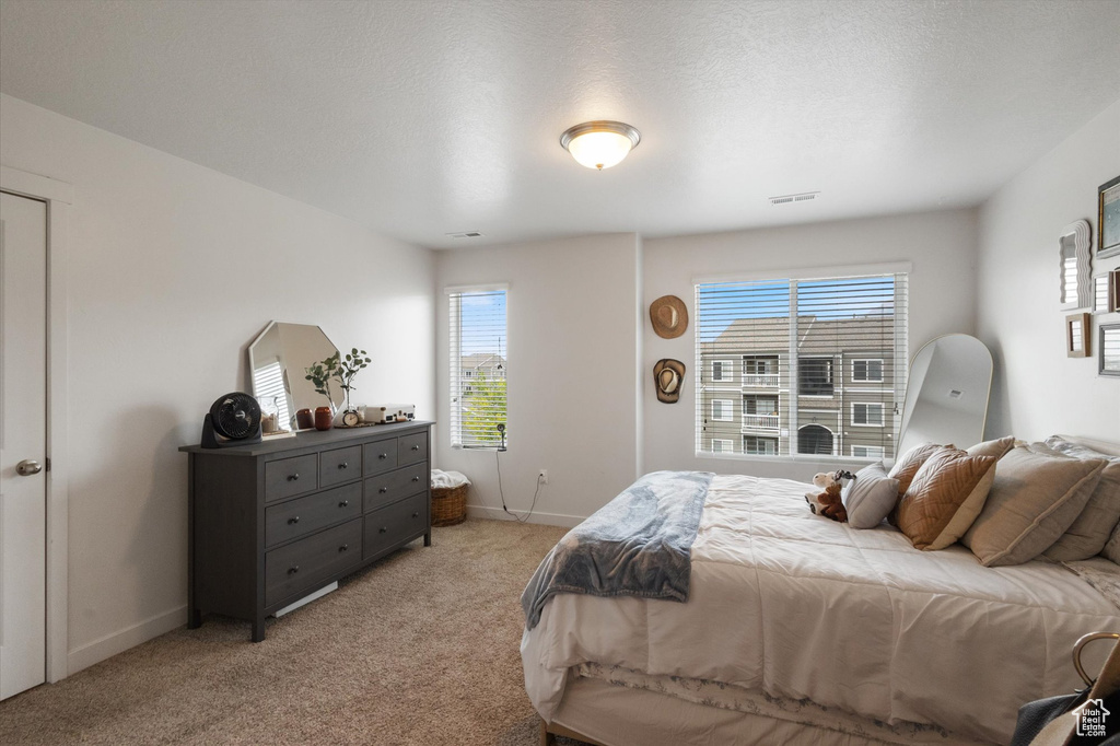 Bedroom featuring light carpet and baseboards