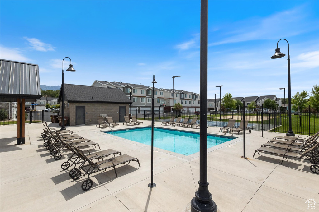 Community pool featuring a patio and a residential view