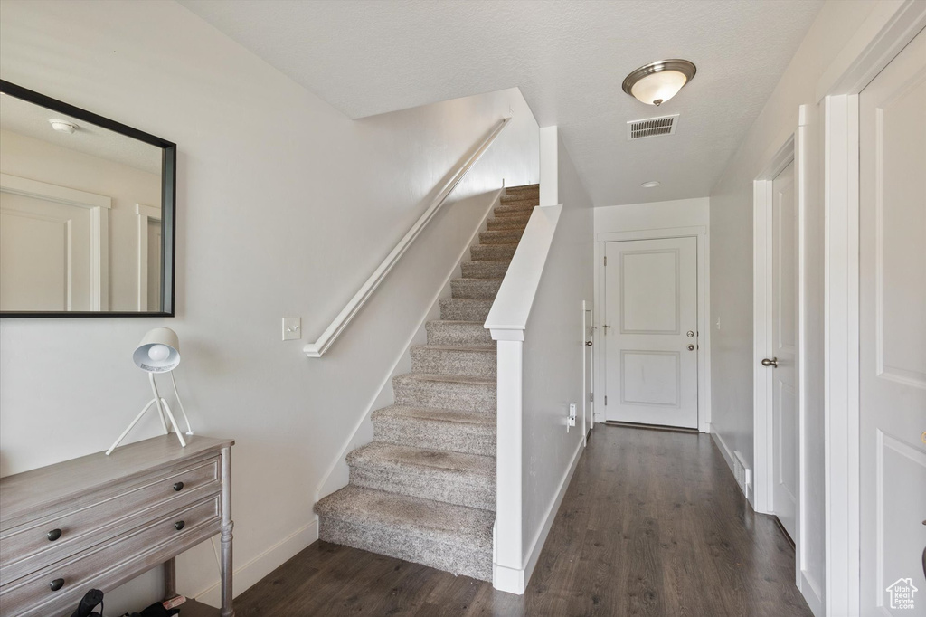 Staircase with wood finished floors and baseboards