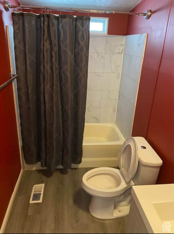 Full bathroom featuring vanity, wood finished floors, and shower / bath combo with shower curtain