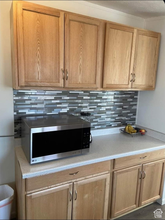 Kitchen featuring stainless steel microwave and decorative backsplash