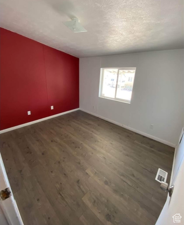 Spare room featuring wood finished floors and baseboards