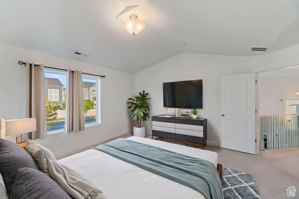 Carpeted bedroom featuring lofted ceiling and baseboards
