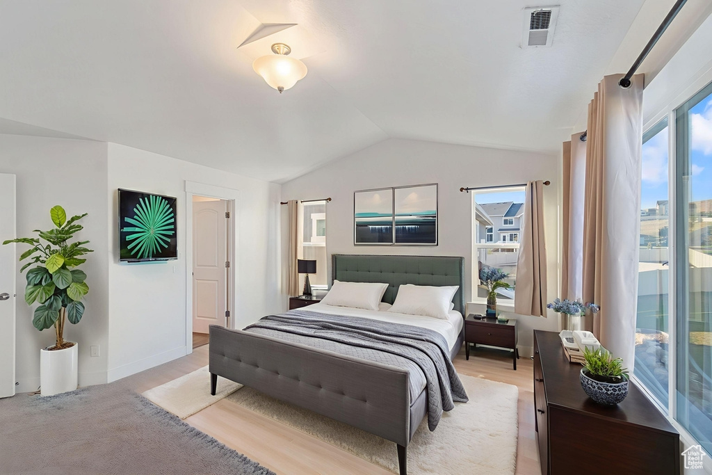 Bedroom with lofted ceiling and light wood-type flooring