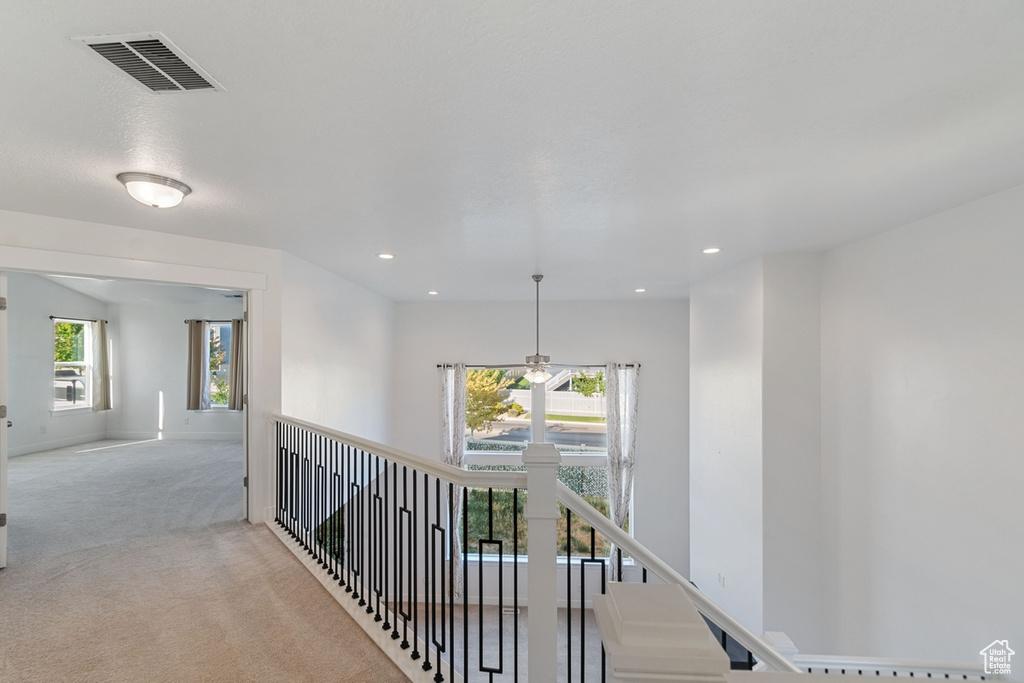 Hall with an upstairs landing, carpet, and recessed lighting