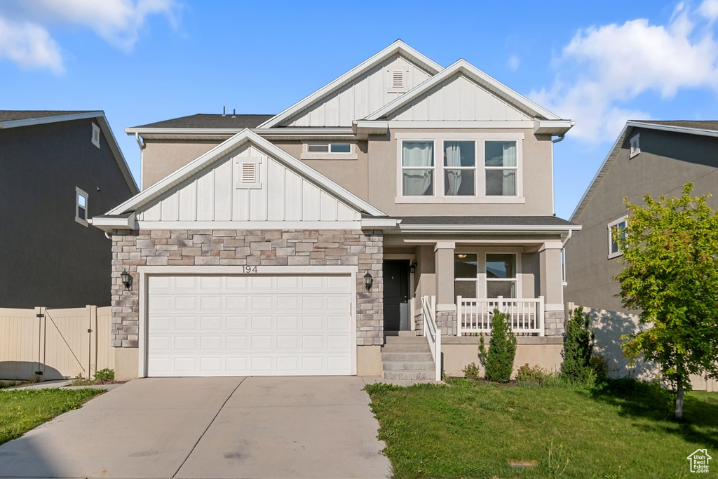 Craftsman house featuring board and batten siding, stone siding, and a porch