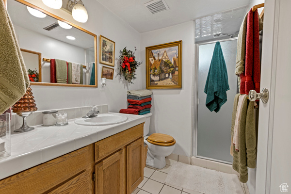 Bathroom featuring tile patterned floors, vanity, and a shower stall