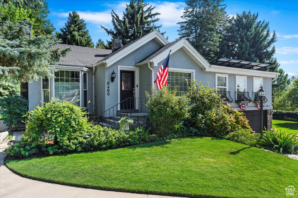 Single story home featuring stucco siding, a front lawn, and an attached garage