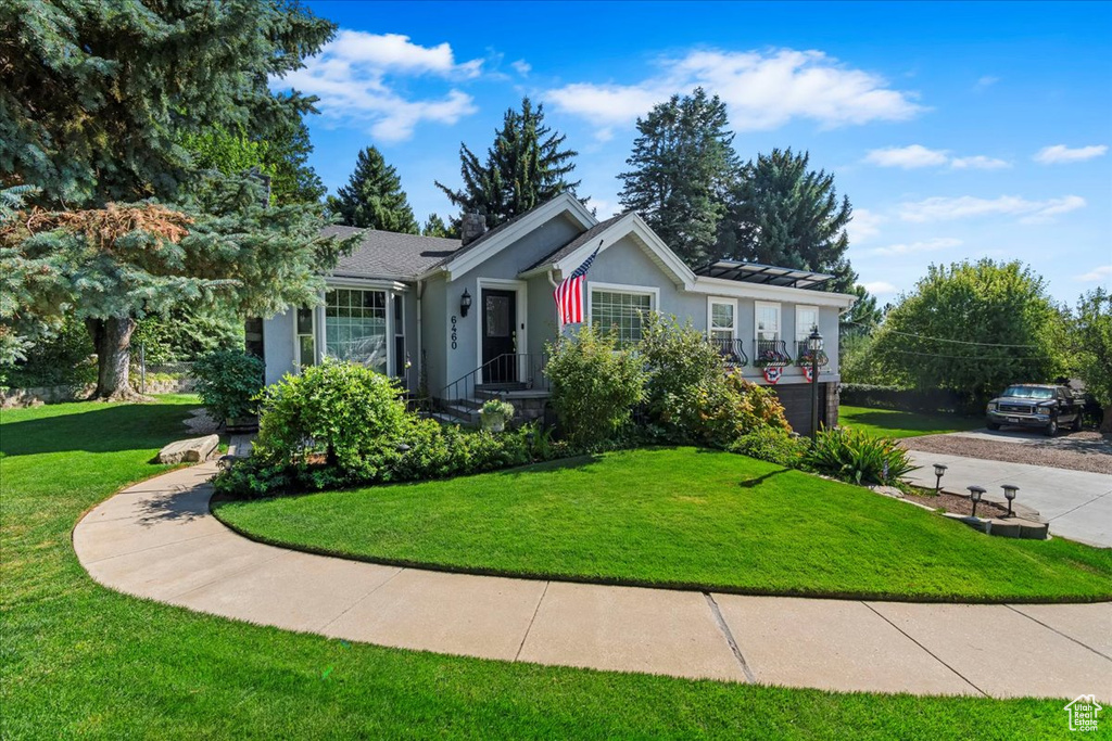 Ranch-style home with stucco siding, a front yard, and concrete driveway