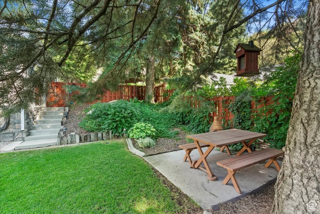 View of yard with a patio area, outdoor dining space, and stairs