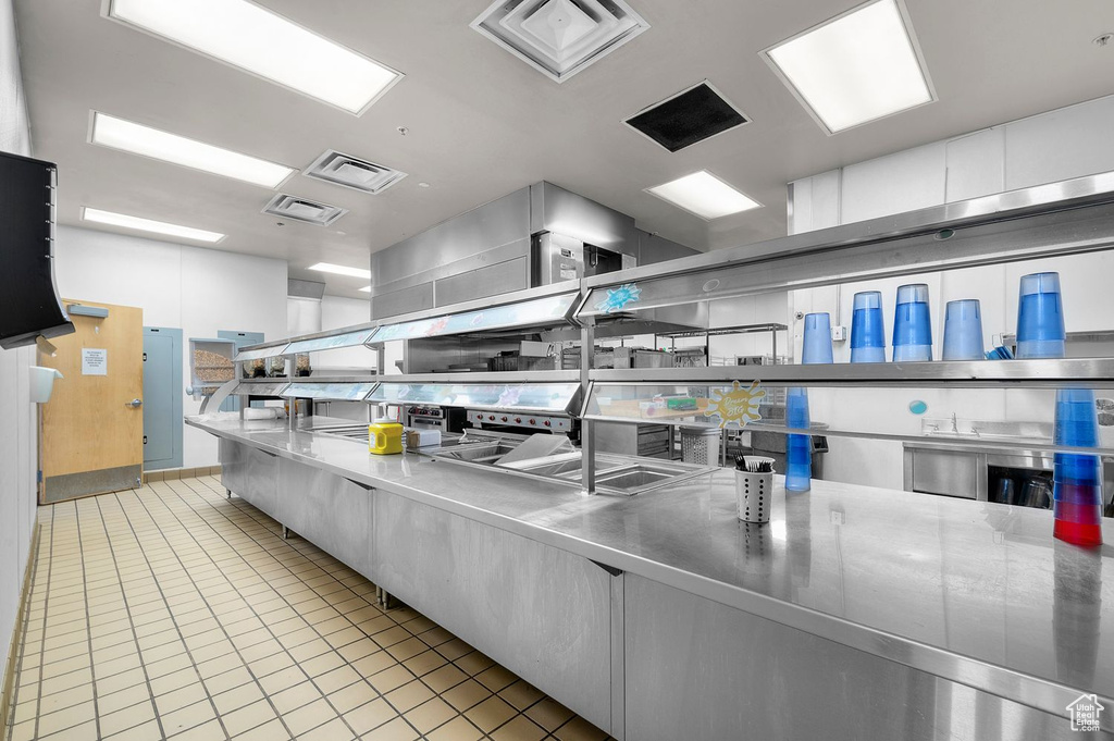 Kitchen with stainless steel counters and light tile patterned floors
