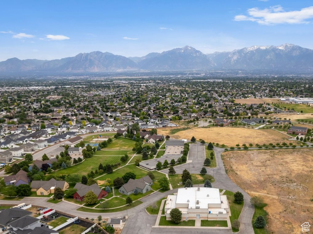 Aerial overview of property's location with a mountainous background and nearby suburban area