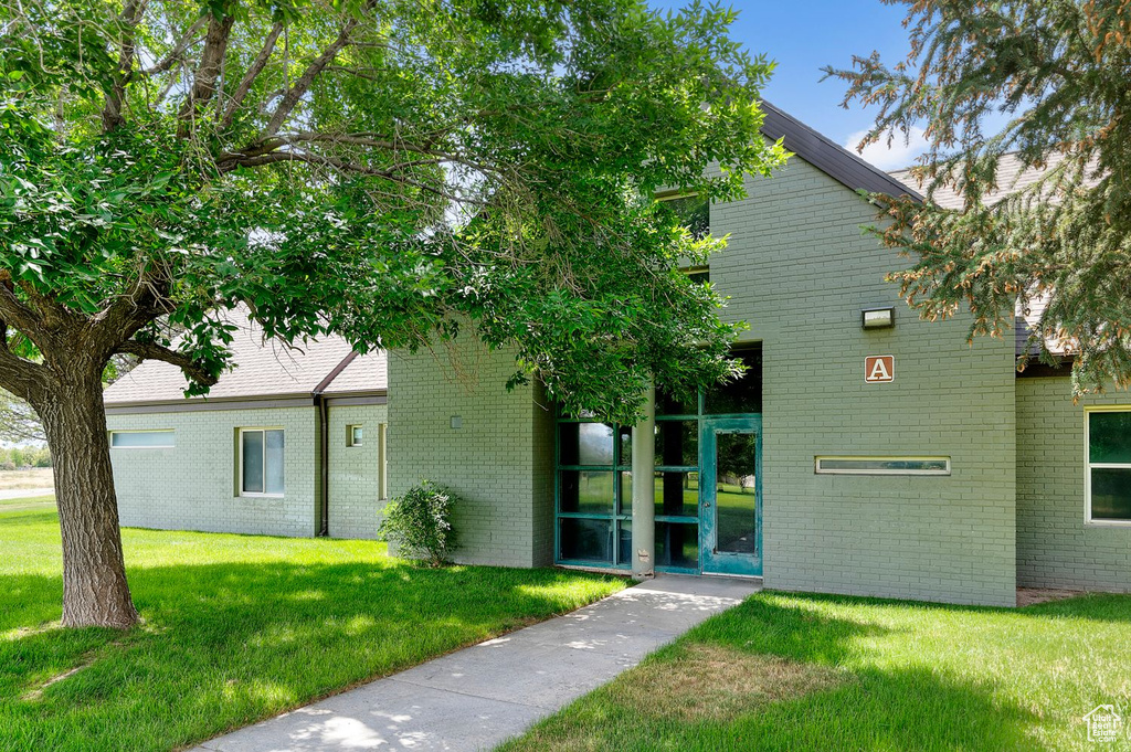 View of front facade with brick siding and a front lawn