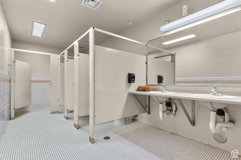 Full bathroom with tile walls