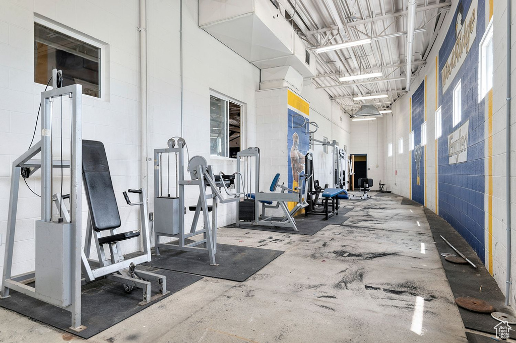 Gym featuring a towering ceiling and concrete block wall