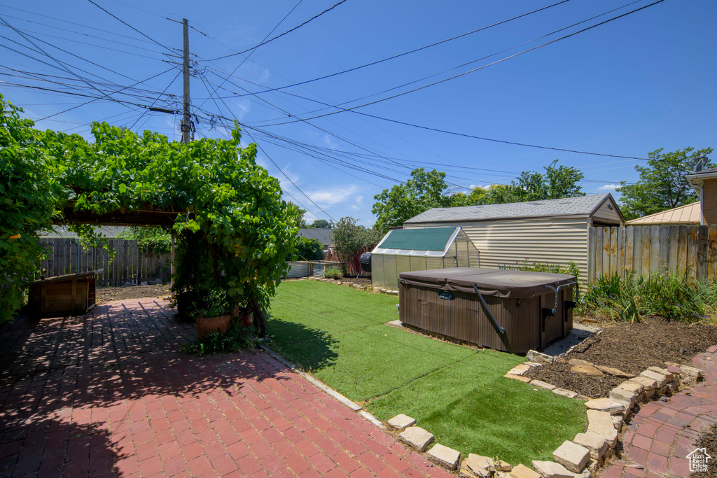 Fenced backyard featuring a hot tub and a patio area