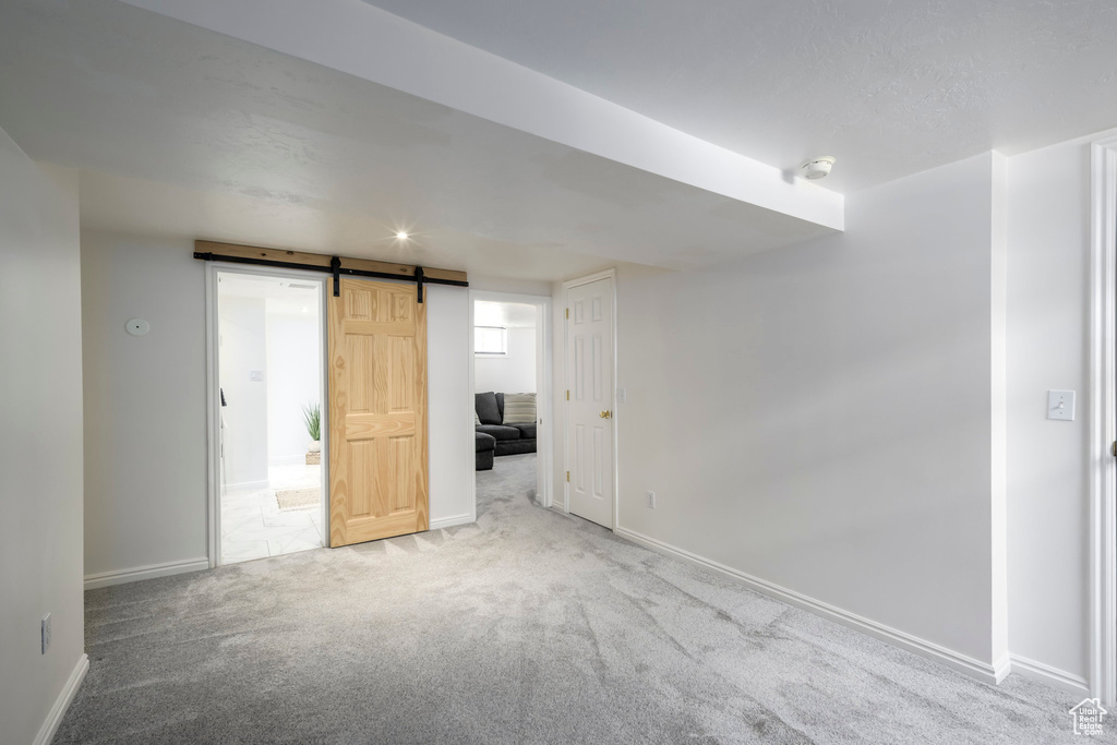 Below grade area featuring carpet and a barn door
