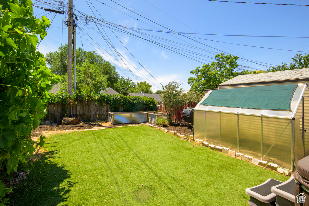 View of yard featuring an exterior structure, an outdoor structure, and a vegetable garden