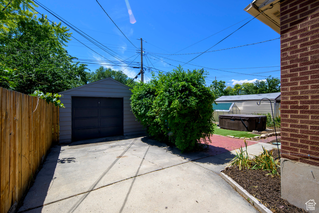 Detached garage featuring concrete driveway