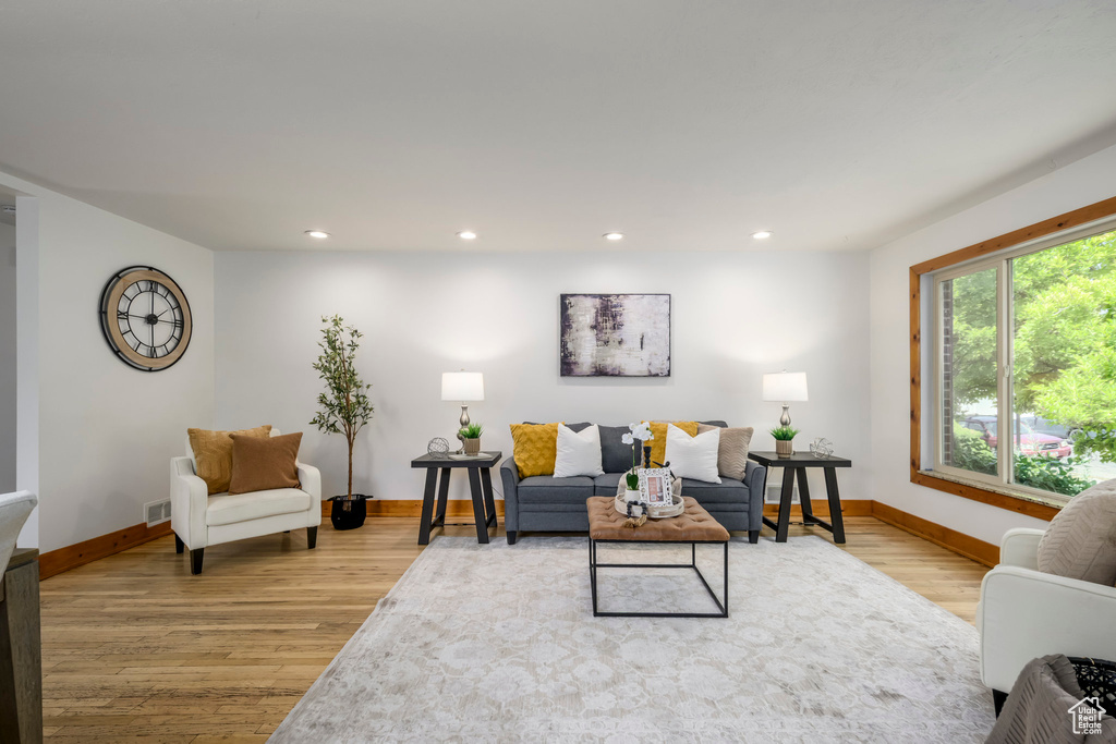 Living room with light wood-style floors and recessed lighting