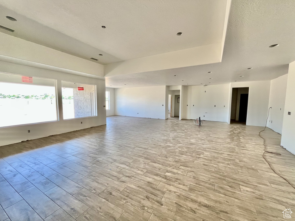 Unfurnished room featuring light wood-style floors and a textured ceiling
