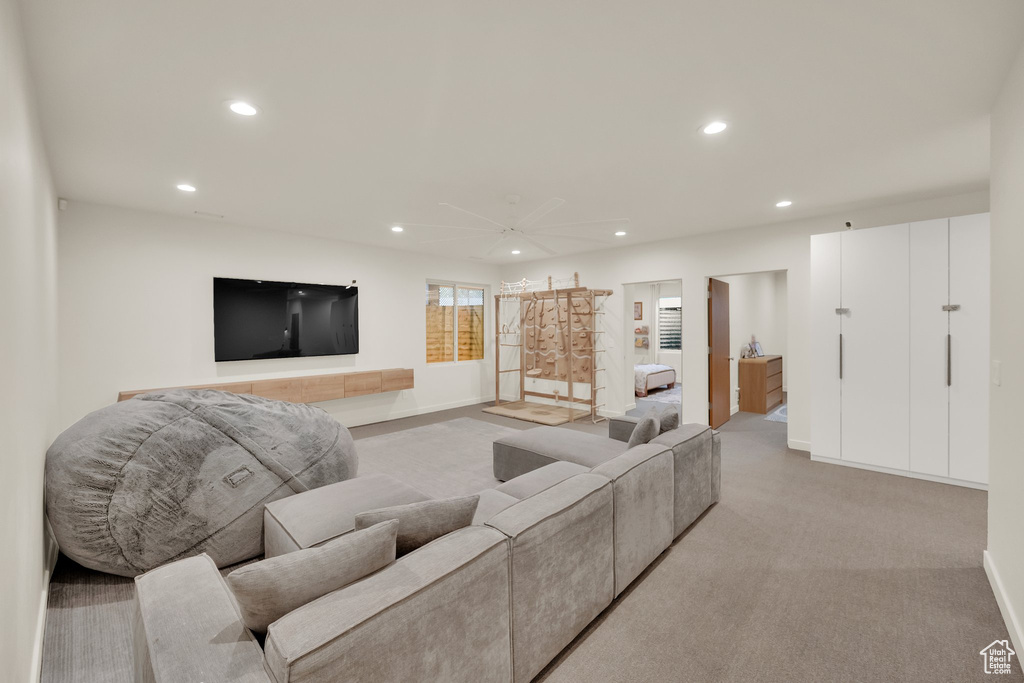 Living area with recessed lighting, light colored carpet, and ceiling fan