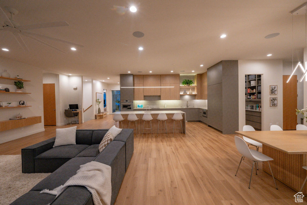 Living room with light wood-type flooring and recessed lighting
