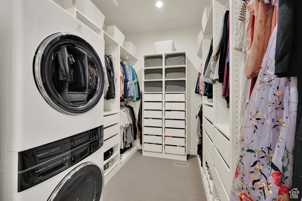 Washroom with estacked washer and dryer, carpet floors, and recessed lighting