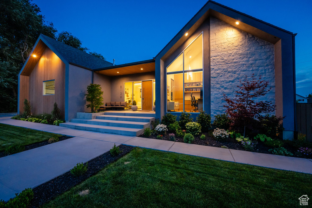 View of front facade featuring a yard and stone siding