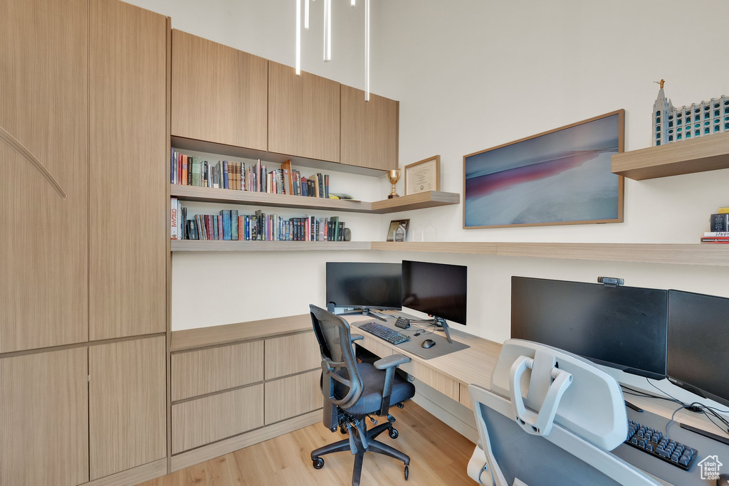 Office with built in desk and light wood finished floors