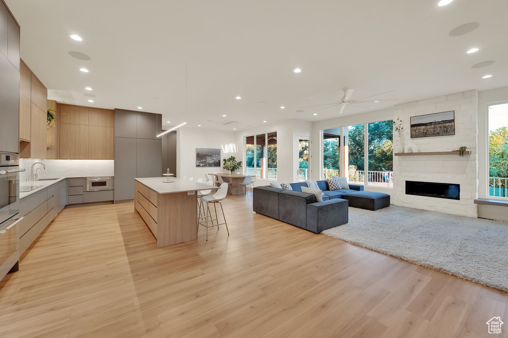 Kitchen featuring modern cabinets, open floor plan, light wood finished floors, plenty of natural light, and recessed lighting