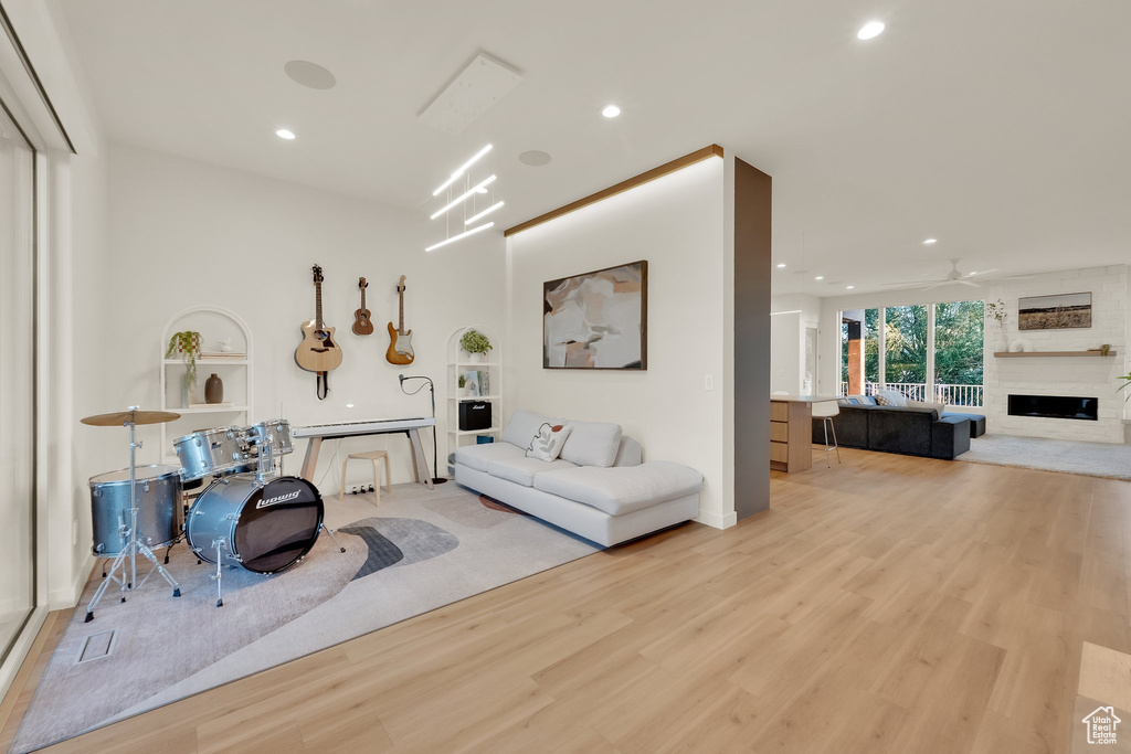 Living area with light wood-type flooring, a fireplace, and recessed lighting