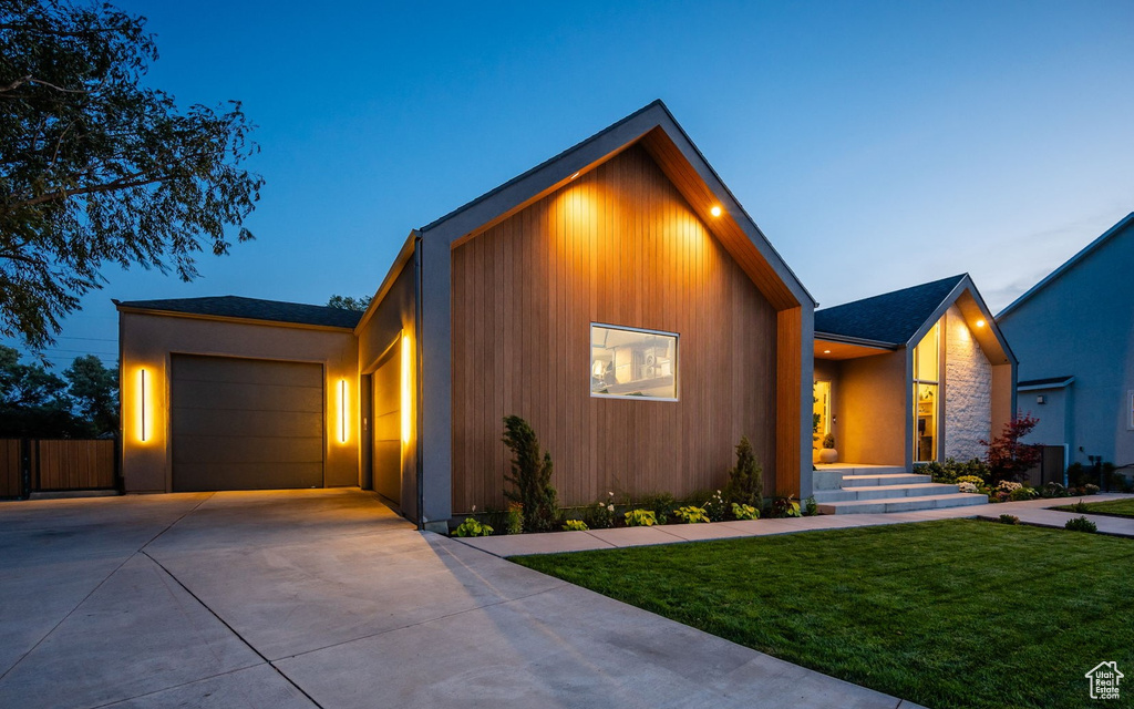 Modern home featuring concrete driveway and a garage