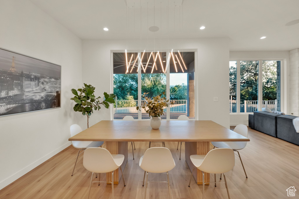 Dining space with light wood-style floors, recessed lighting, and a chandelier