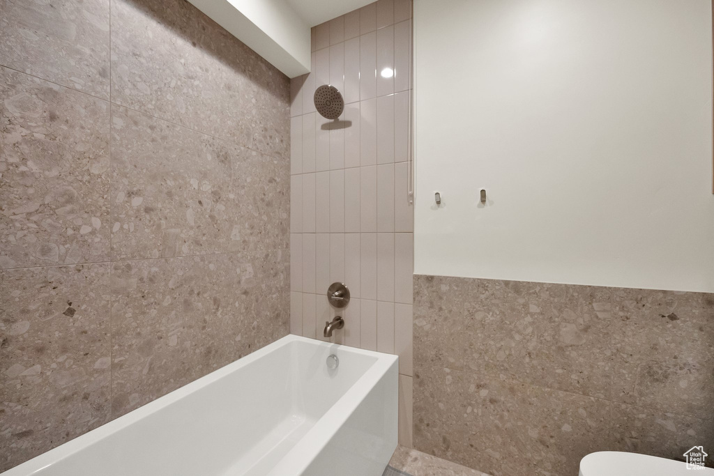 Bathroom featuring tile walls and shower / tub combination