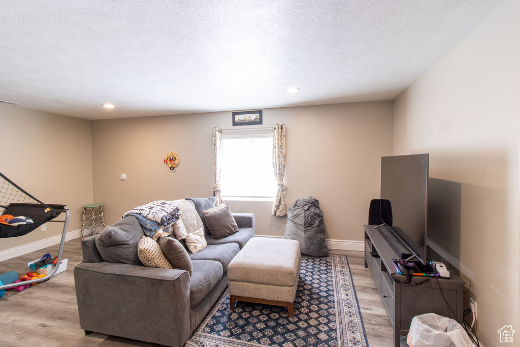 Living area featuring light wood-style flooring, recessed lighting, and a textured ceiling