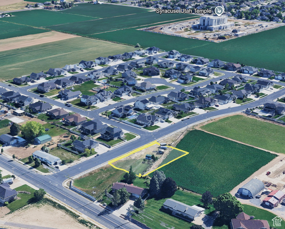 Aerial view of property and surrounding area featuring nearby suburban area