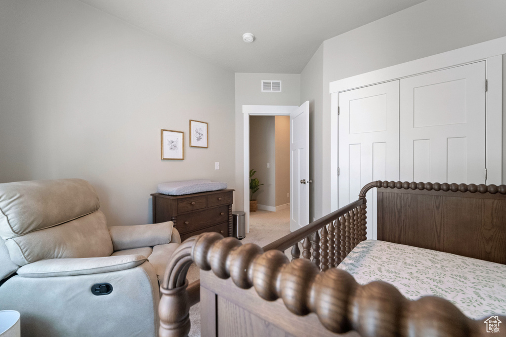 Bedroom featuring light colored carpet and a closet
