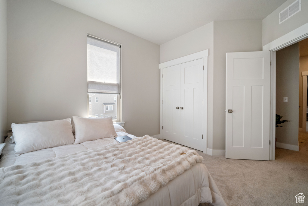 Carpeted bedroom with a closet and cooling unit