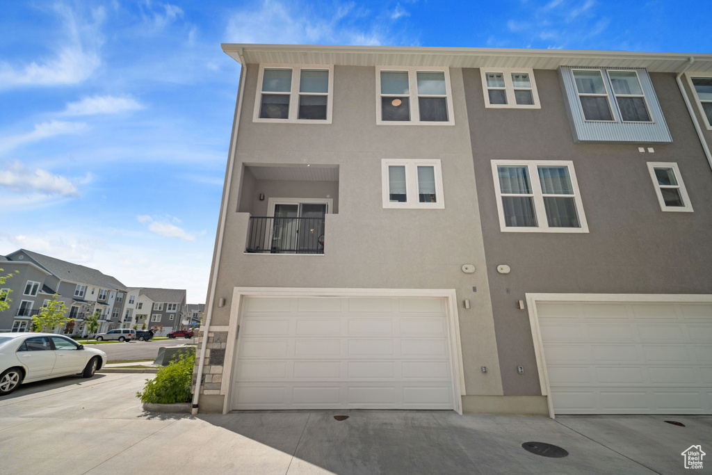 Multi unit property featuring stucco siding, a garage, and a residential view