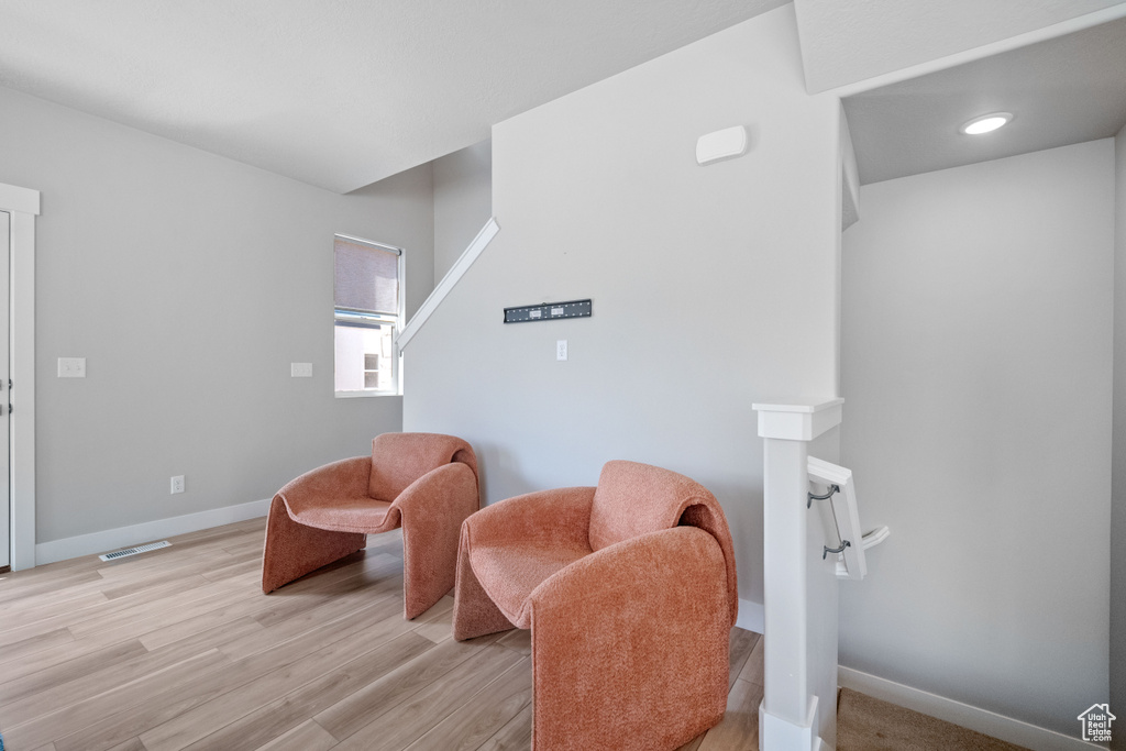 Sitting room with light wood-type flooring and recessed lighting